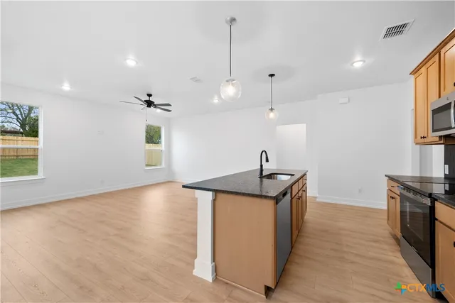 a large kitchen with cabinets and stainless steel appliances