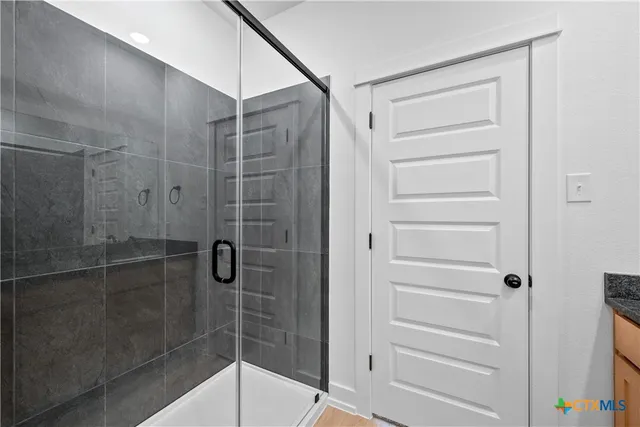 a spacious bathroom with a granite countertop sink and a mirror