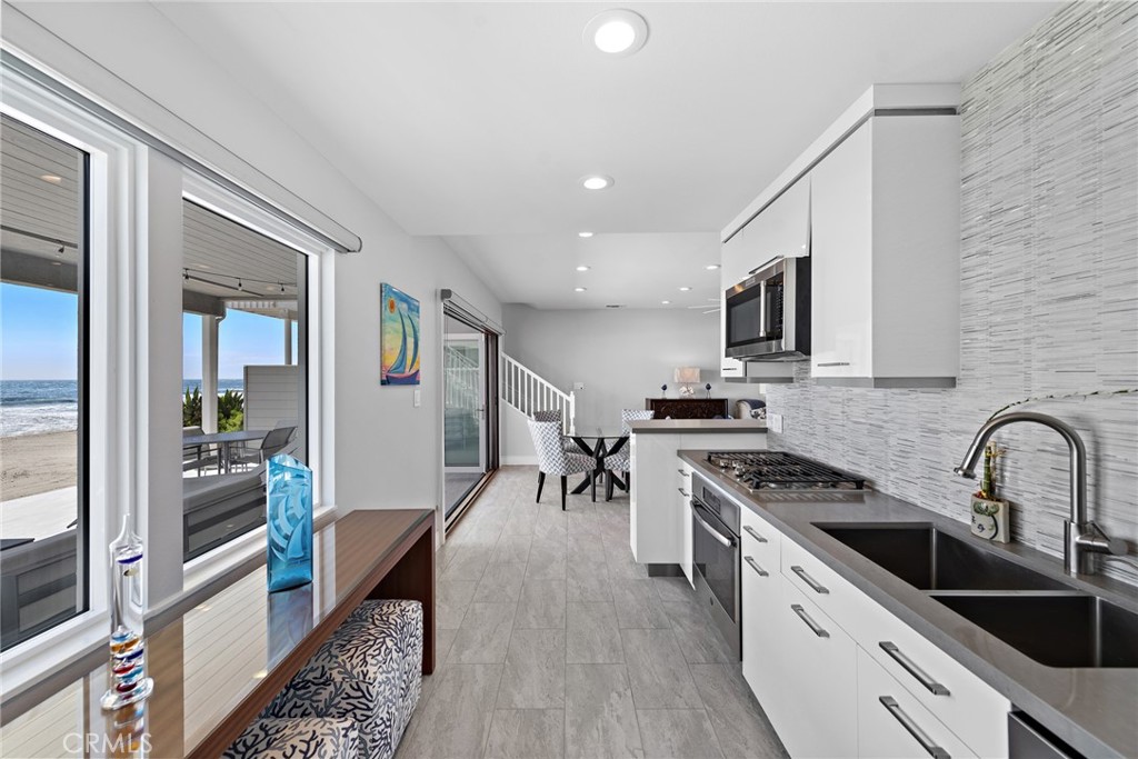 35585 Beach Road Dana Point, CA 92624 - Photo 12 of 43 a kitchen with stainless steel appliances granite countertop a stove top oven a sink a dining table and chairs with wooden floor