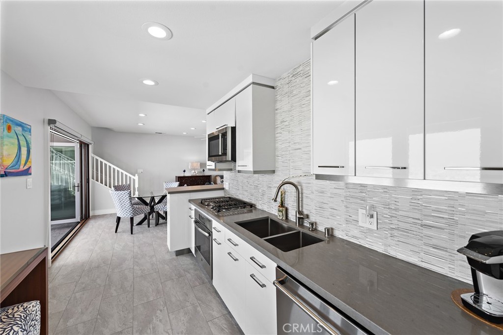 35585 Beach Road Dana Point, CA 92624 - Photo 21 of 43 a kitchen with stainless steel appliances a sink stove and cabinets
