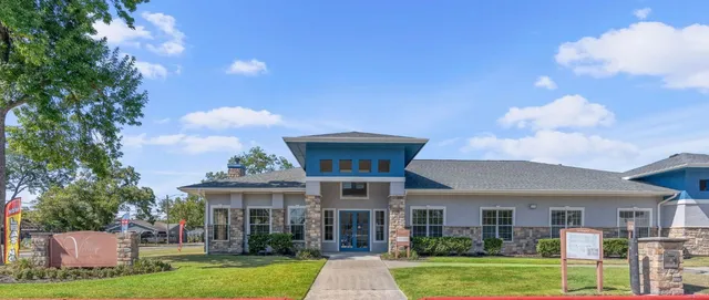 a view of a big house with a big yard and large trees