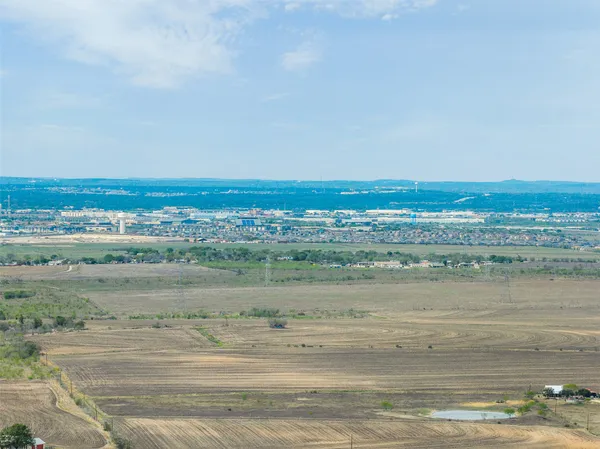 a view of a field with trees in back