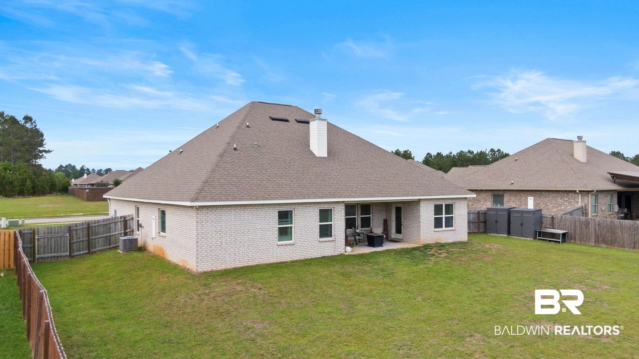 31187 Spoonbill Road Daphne, AL 36527 - Photo 57 of 85 Expansive backyard featuring a manicured lawn, full perimeter wood fencing, and a concrete patio