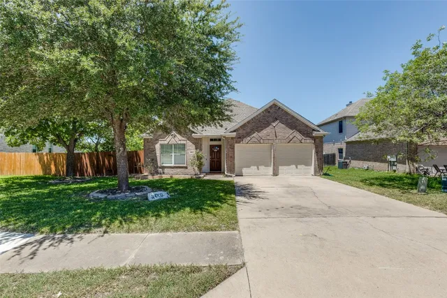 a front view of a house with a yard and a garage