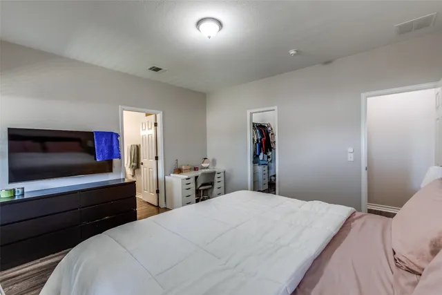 a bedroom with a bed and a flat screen tv