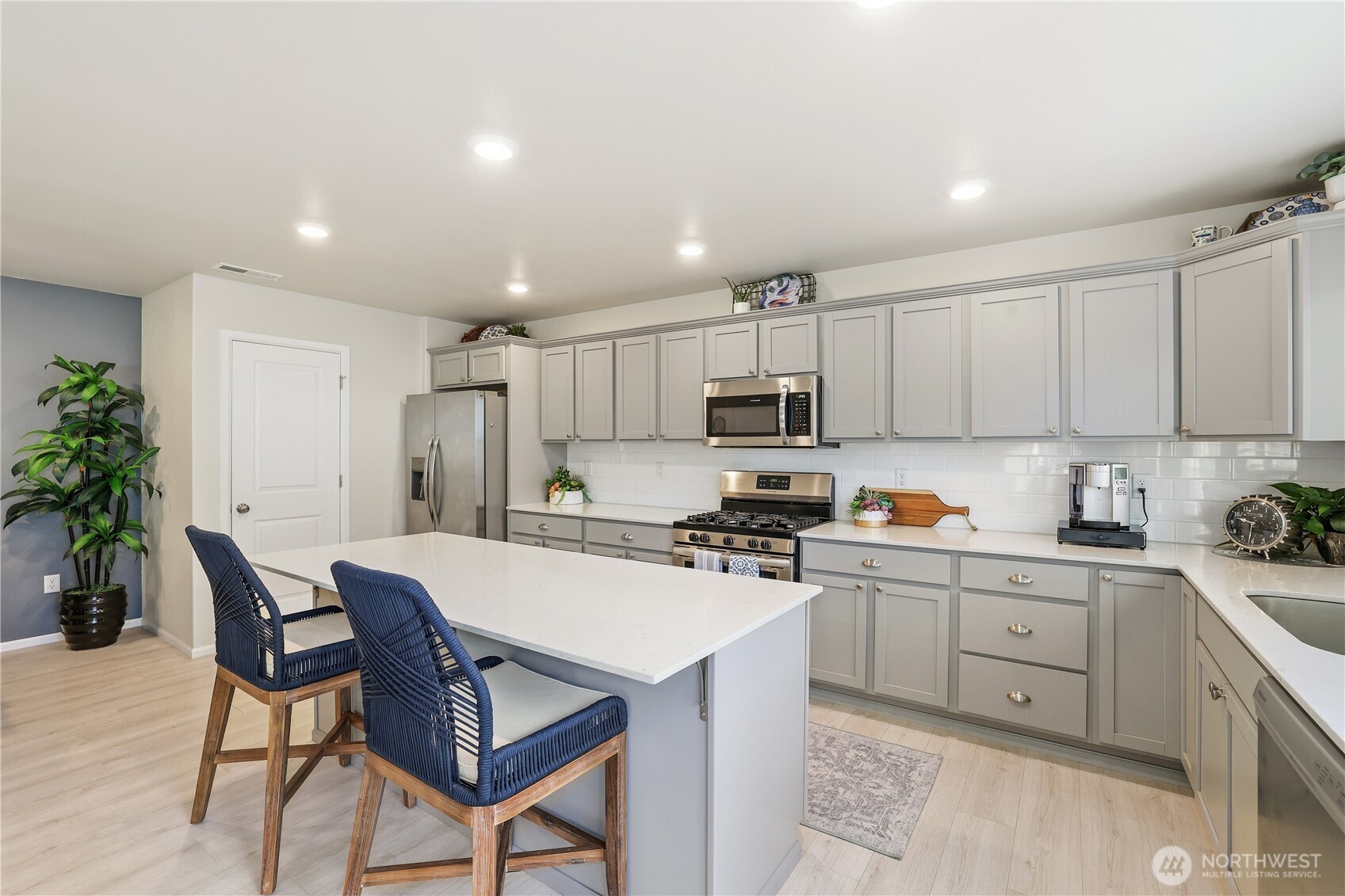 19908 135th Avenue East Graham, WA 98338 - Photo 15 of 39 a kitchen with stainless steel appliances a table and chairs in it