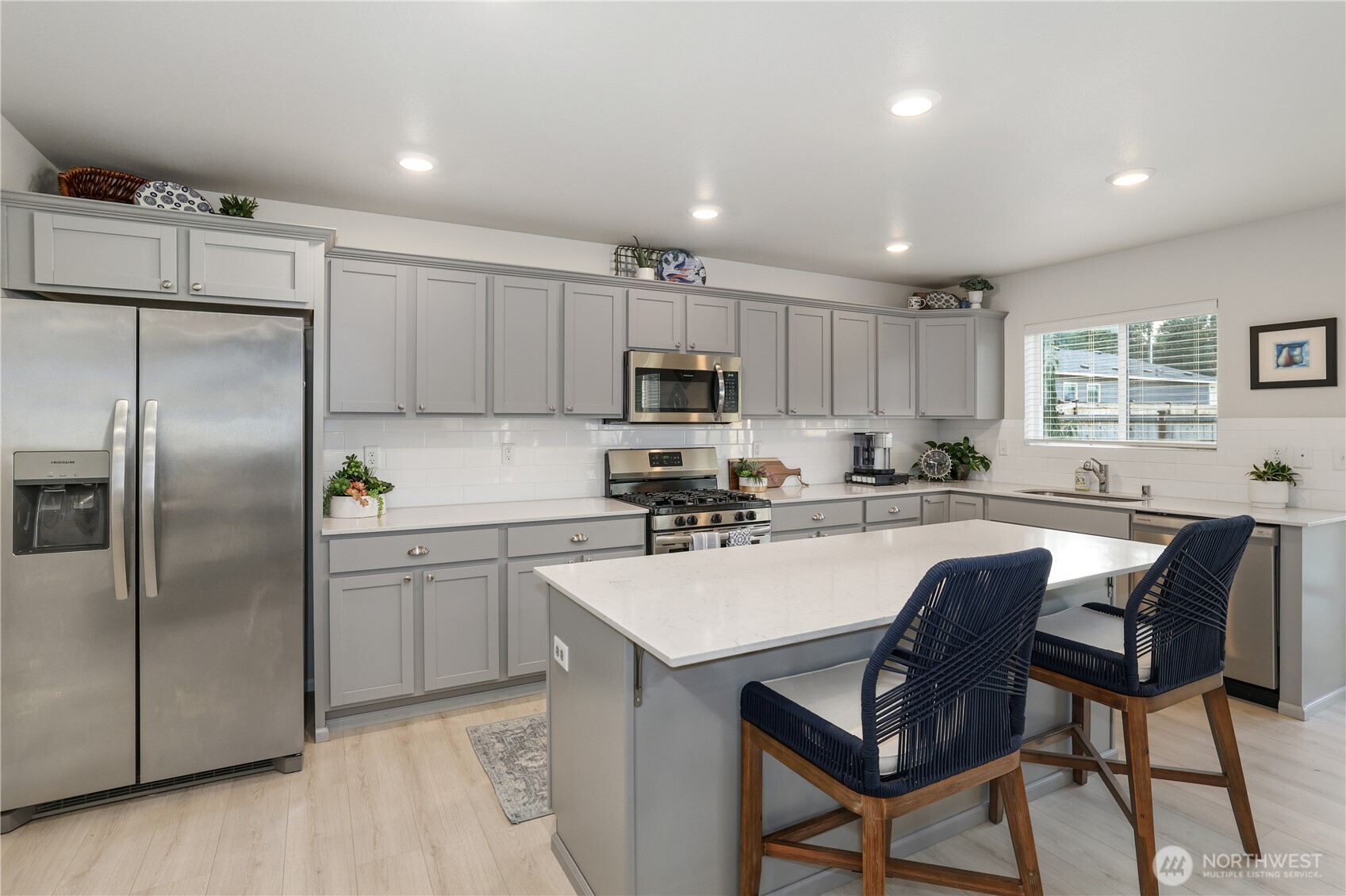 19908 135th Avenue East Graham, WA 98338 - Photo 10 of 39 a kitchen with kitchen island a refrigerator and a stove top oven