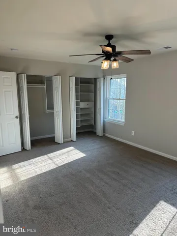 a view of a livingroom with a ceiling fan and window