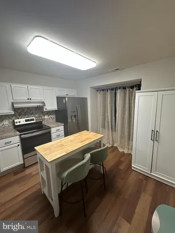 a kitchen with a table chairs and refrigerator