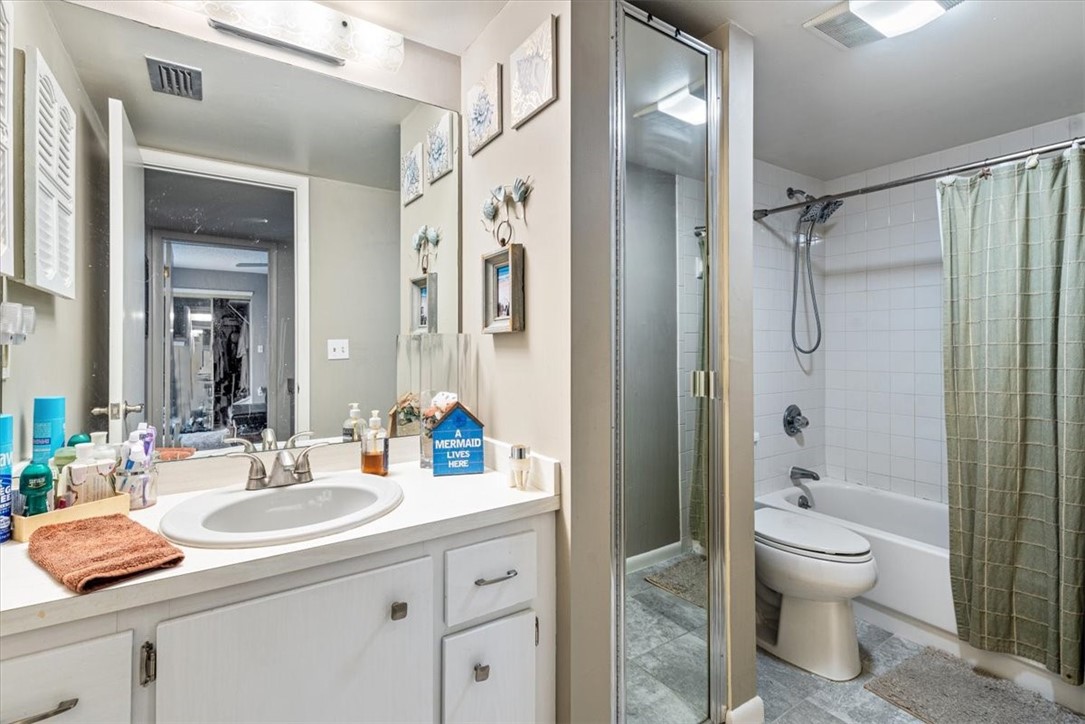 1170 6th Avenue, Unit 9D Vero Beach, FL 32960 - Photo 20 of 23 a bathroom with a granite countertop sink toilet a shower and a mirror