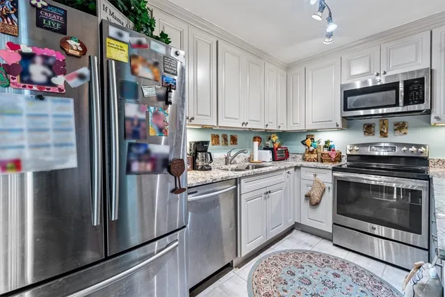 a kitchen with stainless steel appliances granite countertop a refrigerator and a stove top oven