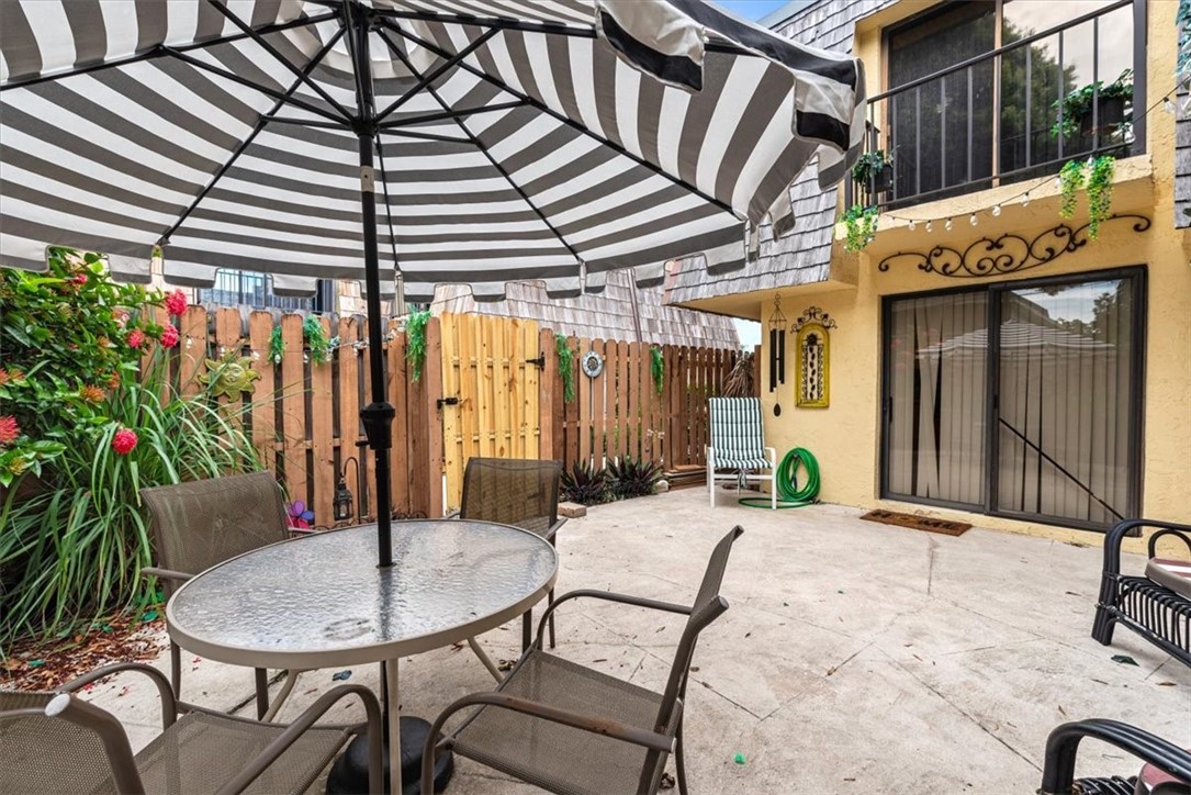 1170 6th Avenue, Unit 9D Vero Beach, FL 32960 - Photo 10 of 23 a backyard of a house with barbeque oven table and chairs