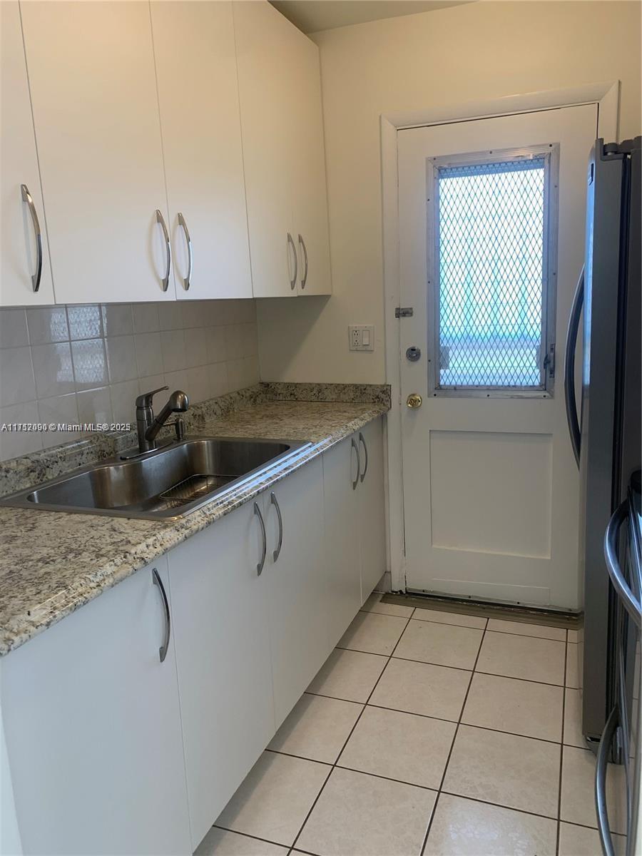 1395 Northeast 167th Street, Unit 209 Miami, FL 33162 - Photo 13 of 28 a kitchen with a sink a stove and cabinets