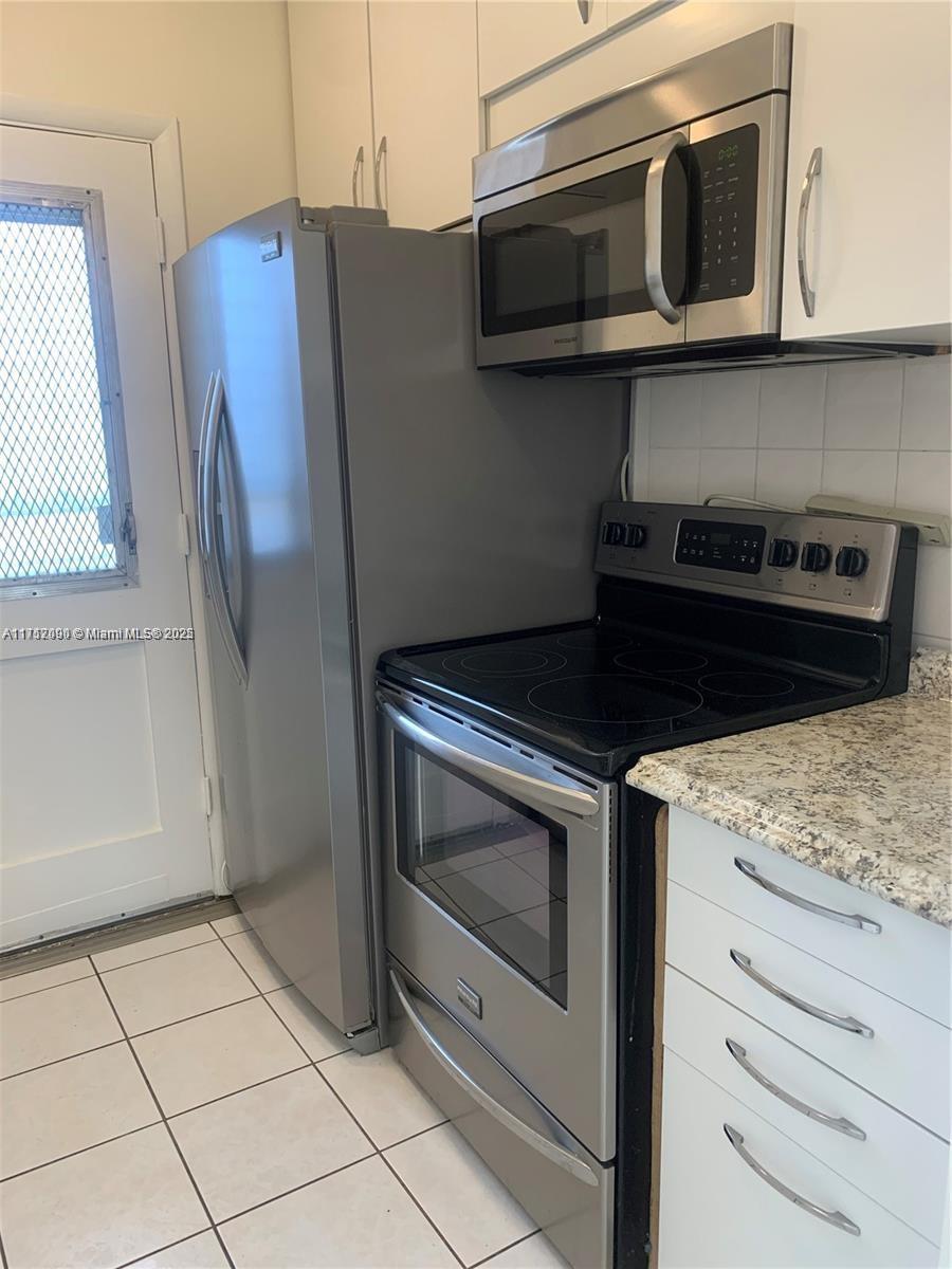1395 Northeast 167th Street, Unit 209 Miami, FL 33162 - Photo 14 of 28 a kitchen with stainless steel appliances granite countertop a stove microwave and refrigerator