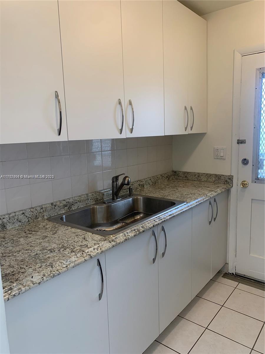 1395 Northeast 167th Street, Unit 209 Miami, FL 33162 - Photo 15 of 28 a kitchen with granite countertop a sink a stove and cabinets