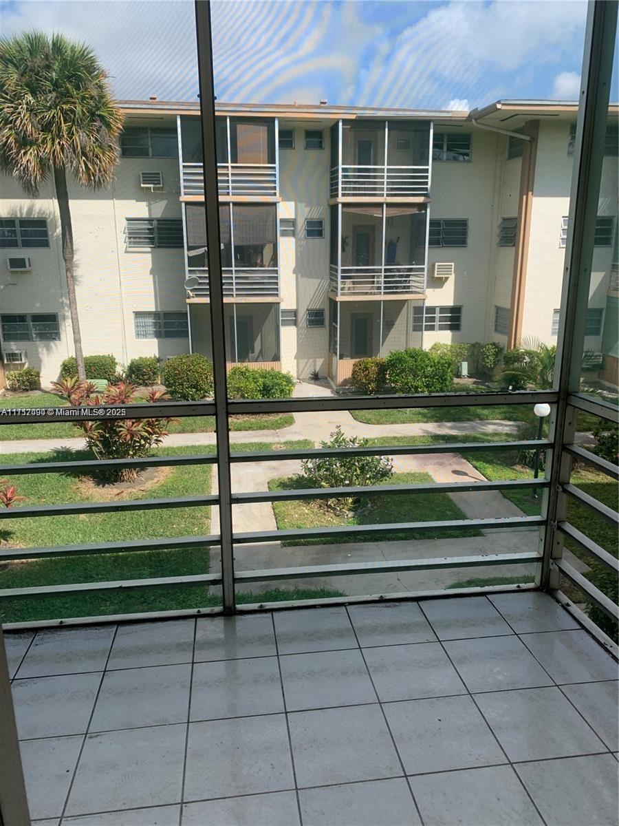 1395 Northeast 167th Street, Unit 209 Miami, FL 33162 - Photo 2 of 28 a front view of a house with a garden