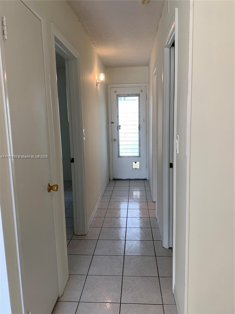 1395 Northeast 167th Street, Unit 209 Miami, FL 33162 - Photo 22 of 28 a view of hallway with a window and a bathroom
