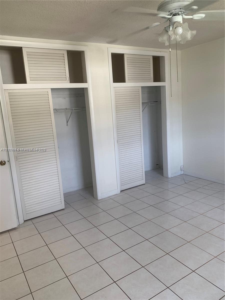 1395 Northeast 167th Street, Unit 209 Miami, FL 33162 - Photo 24 of 28 a view of walk in closet with empty racks