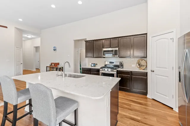 a large kitchen with a table chairs refrigerator and microwave
