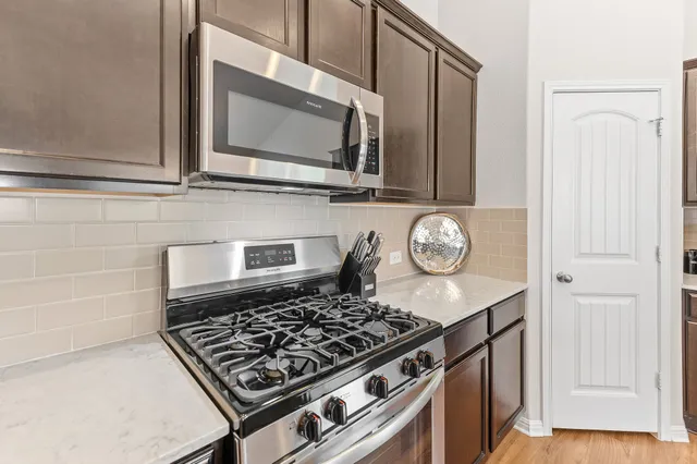 a kitchen with granite countertop a stove and a microwave