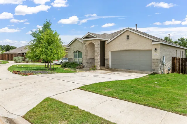 a front view of a house with a garden and yard