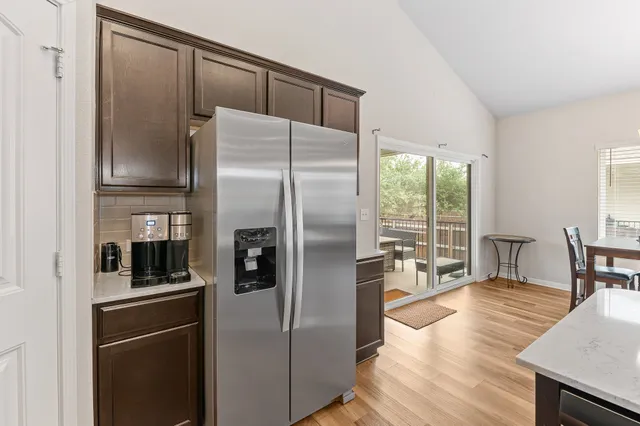 a kitchen with stainless steel appliances a refrigerator and wooden floor
