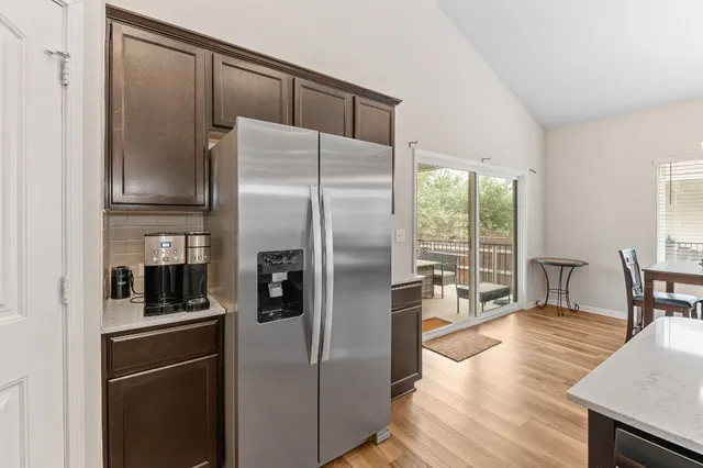 a kitchen with stainless steel appliances a refrigerator and wooden floor