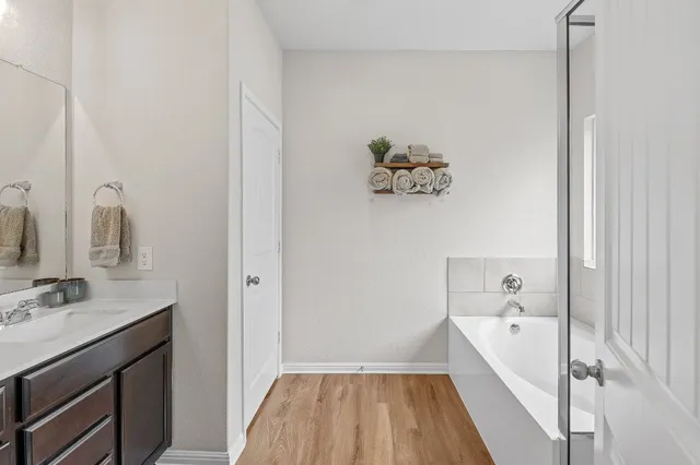 a bathroom with a tub sink and mirror