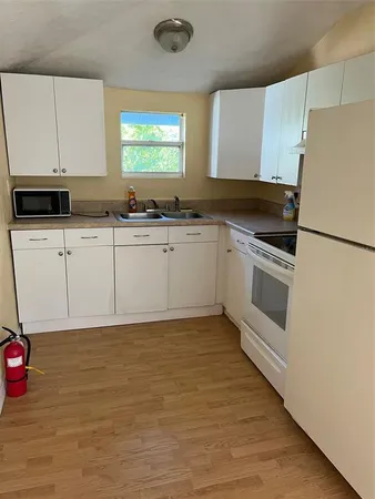 a kitchen with granite countertop a stove a sink and a refrigerator
