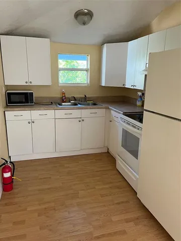 a kitchen with granite countertop a stove a sink and a refrigerator