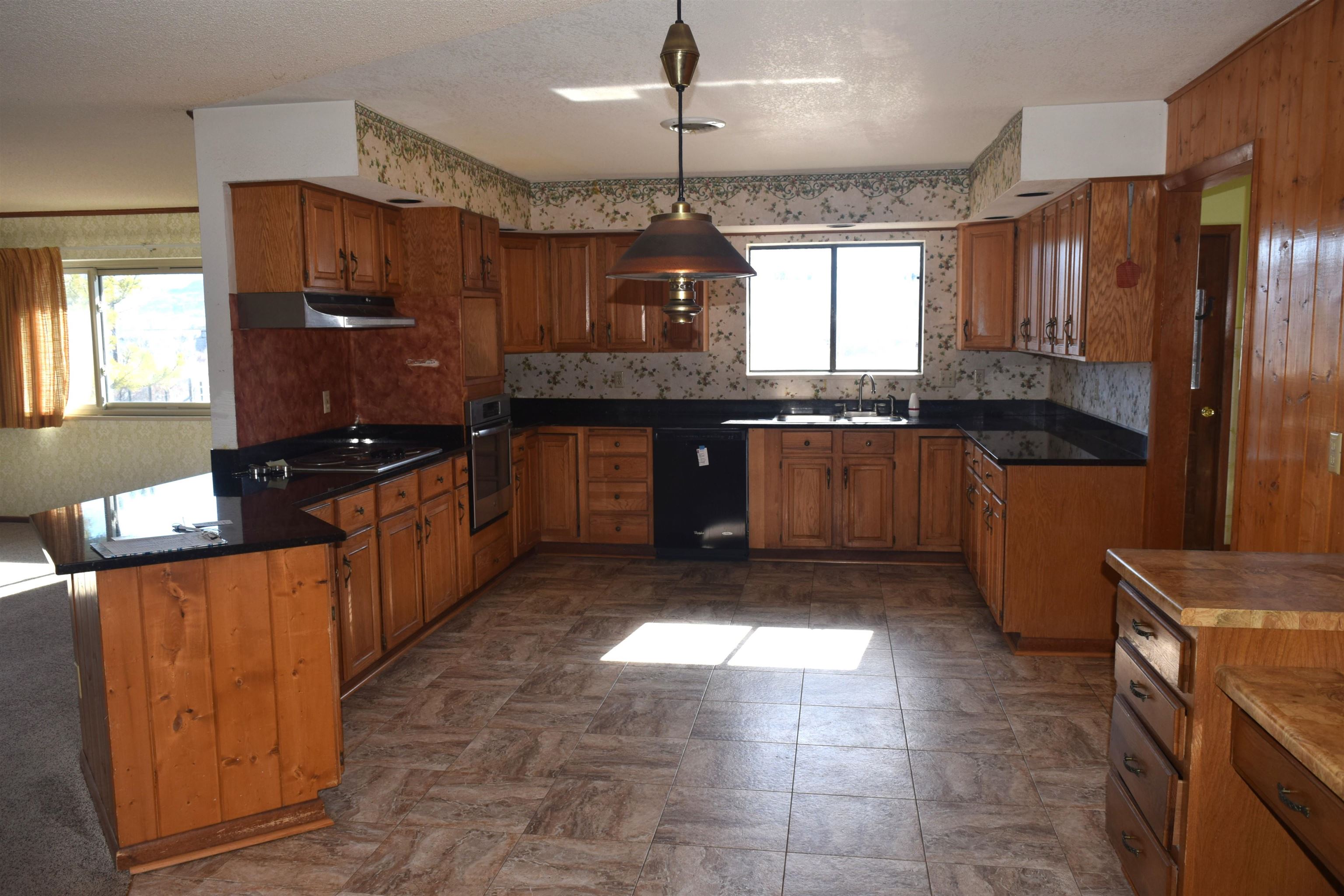 4399 44 Road De Beque, CO 81630 - Photo 5 of 31 a kitchen with granite countertop a stove a sink dishwasher and a refrigerator