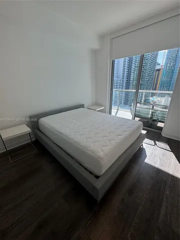 a bedroom with furniture and a large window