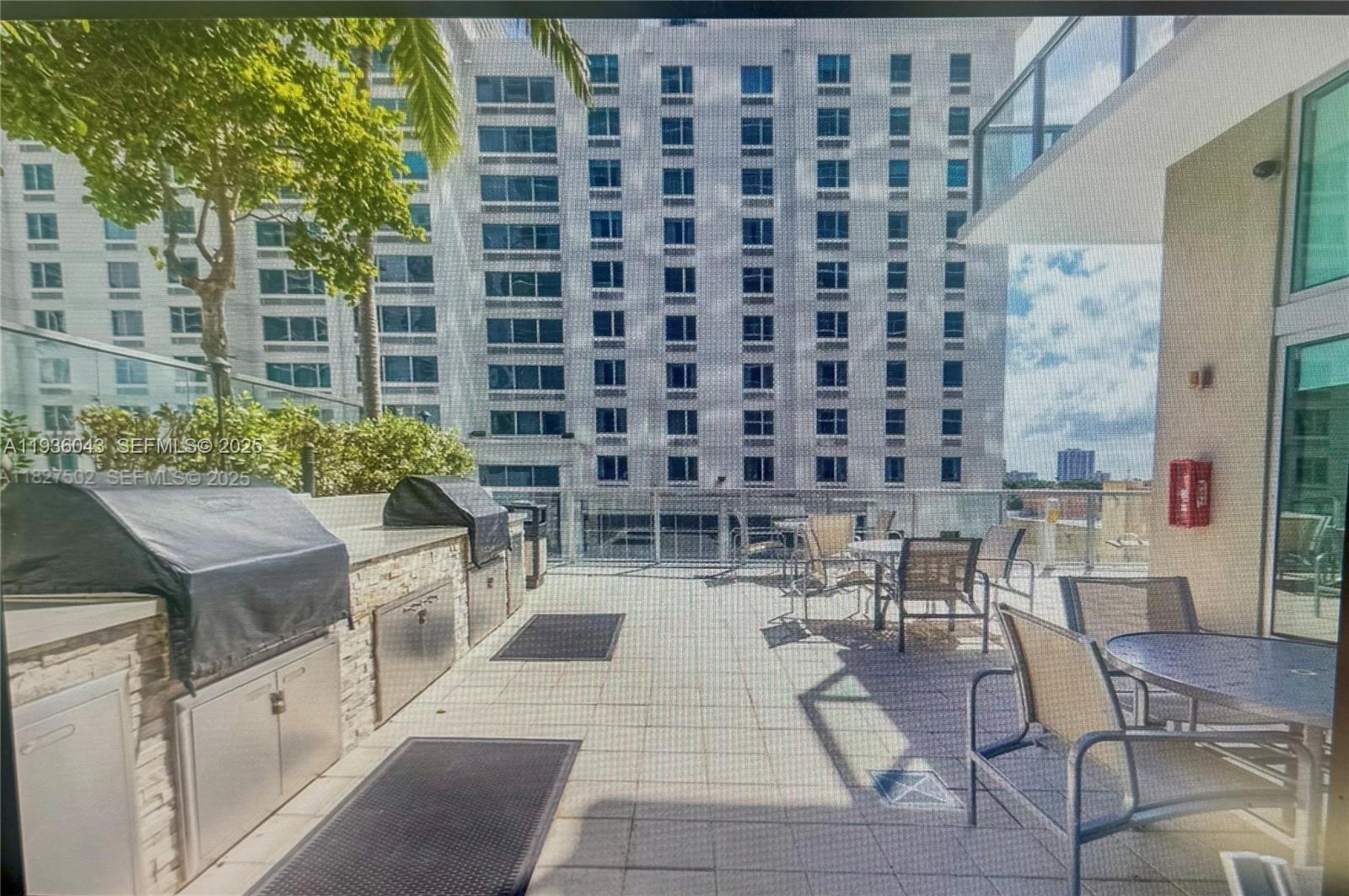 1111 Southwest 1st Street, Unit 2616 Miami, FL 33130 - Photo 27 of 27 a view of a patio with couches table and chairs and potted plants