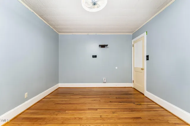 a view of a room with a window and wooden floor