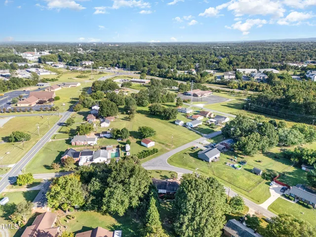 a view of a house with a yard and large tree