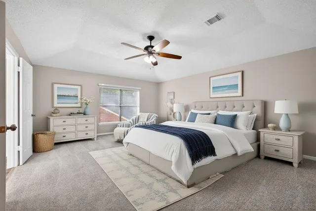a spacious bedroom with a bed and a chandelier