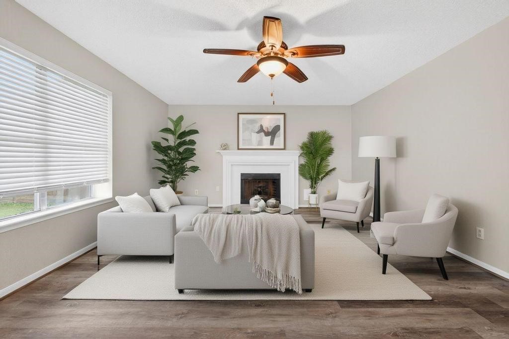 8815 Stoney Bend Drive Spring, TX 77379 - Photo 4 of 50 This inviting living room features a cozy fireplace, modern ceiling fan, and abundant natural light from a large window.