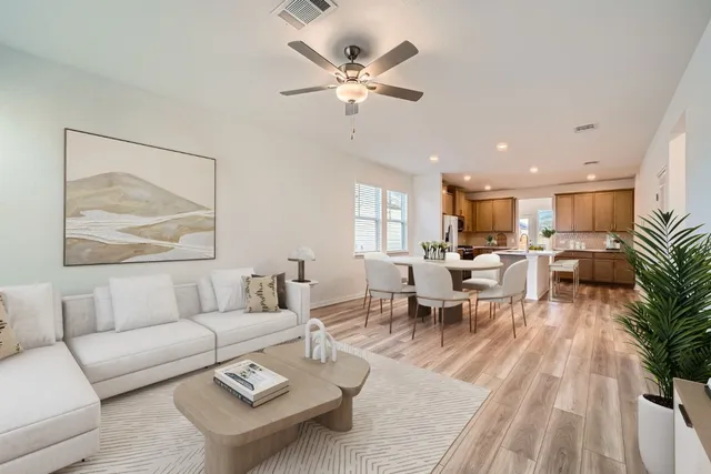 a living room with furniture kitchen view and a chandelier