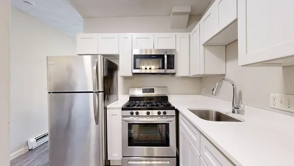 a kitchen with a refrigerator sink and stove top oven