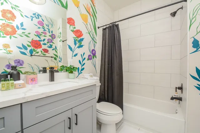 a bathroom with a sink a toilet and a shower curtain