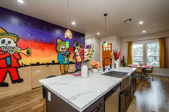 a view of a dining room with furniture one side kitchen view and wooden floor