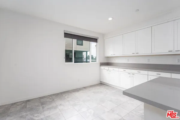 a large kitchen with stainless steel appliances a large counter top a stove and a refrigerator