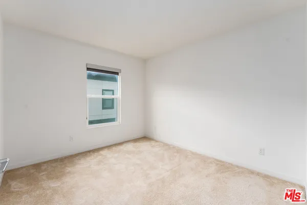 a view of an empty room with a fireplace and a window