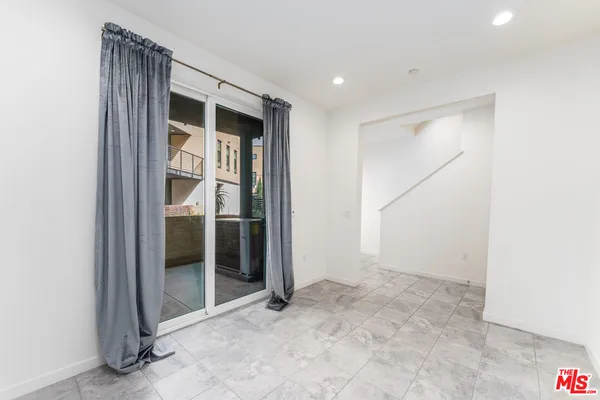 a large white kitchen with a sink a counter top space and stainless steel appliances