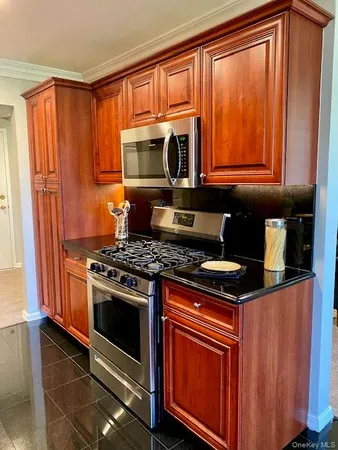 a kitchen with stainless steel appliances granite countertop a stove a sink and a microwave