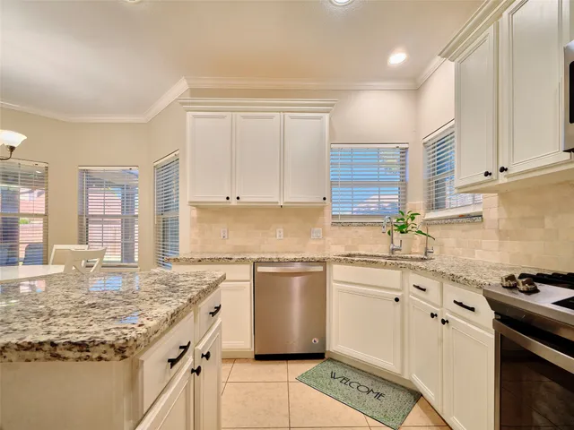 a kitchen with stainless steel appliances granite countertop a sink stove and cabinets