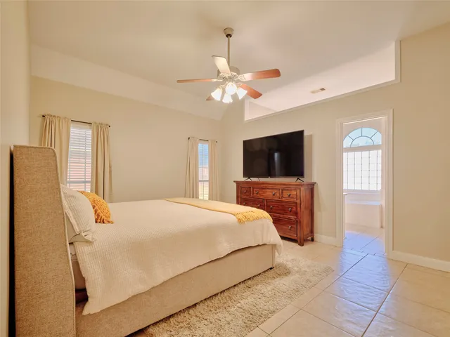 a bedroom with a bed flat screen tv and a window