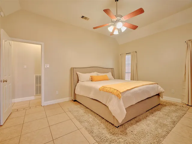 a bedroom with a bed and a ceiling fan