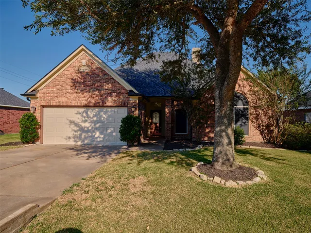 a view of a house with backyard and tree