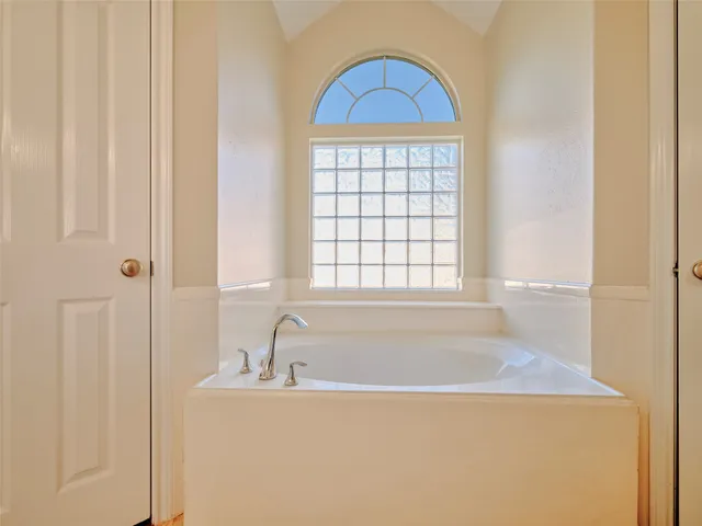 a bathroom with a bathtub and a window